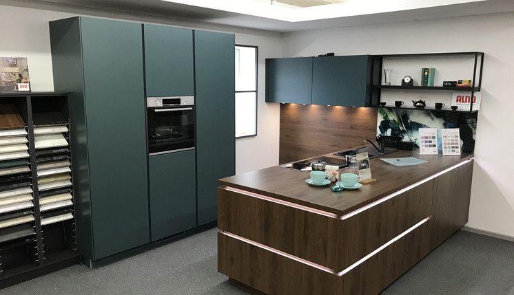 ALNO Showroom-Küche in Petrolblau und Walnuss mit Kochinsel und Materialauswahl