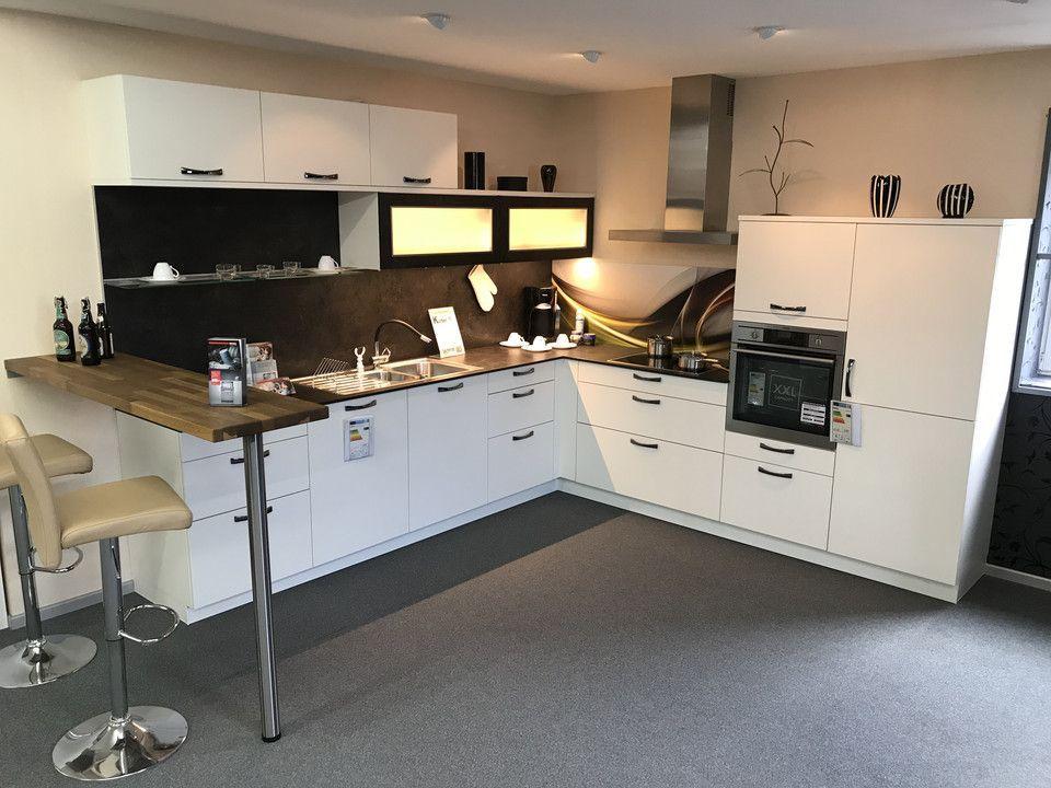 Unsere Ausstellung in Bischberg — Showroomküche weiß mit Holz-Bartresen, Edelstahl-Dunstabzug und gelben Barhockern