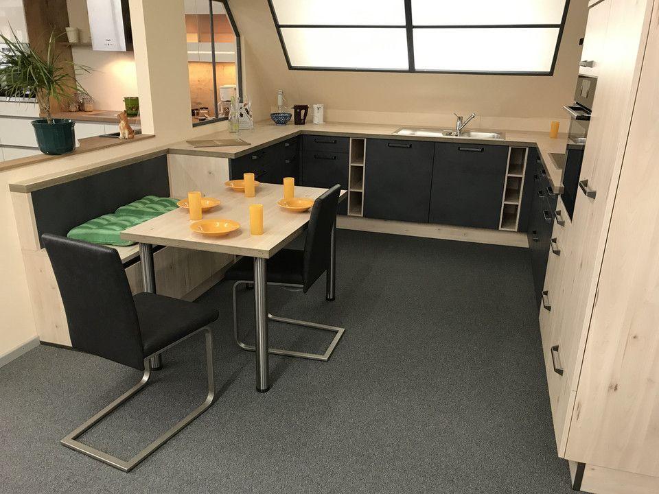 Unsere Ausstellung in Bischberg — Showroomküche mit dunklen Fronten, Esstisch mit Stühlen und gelben Kerzen