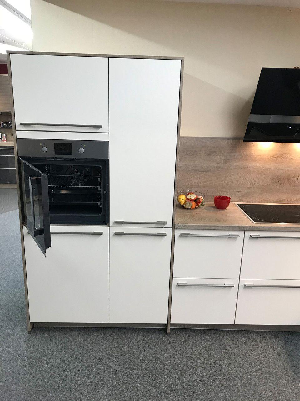 Unsere Ausstellung in Bischberg — Weiße Küche mit geöffnetem Backofen und Holz-Akzent zwischen Hochschränken