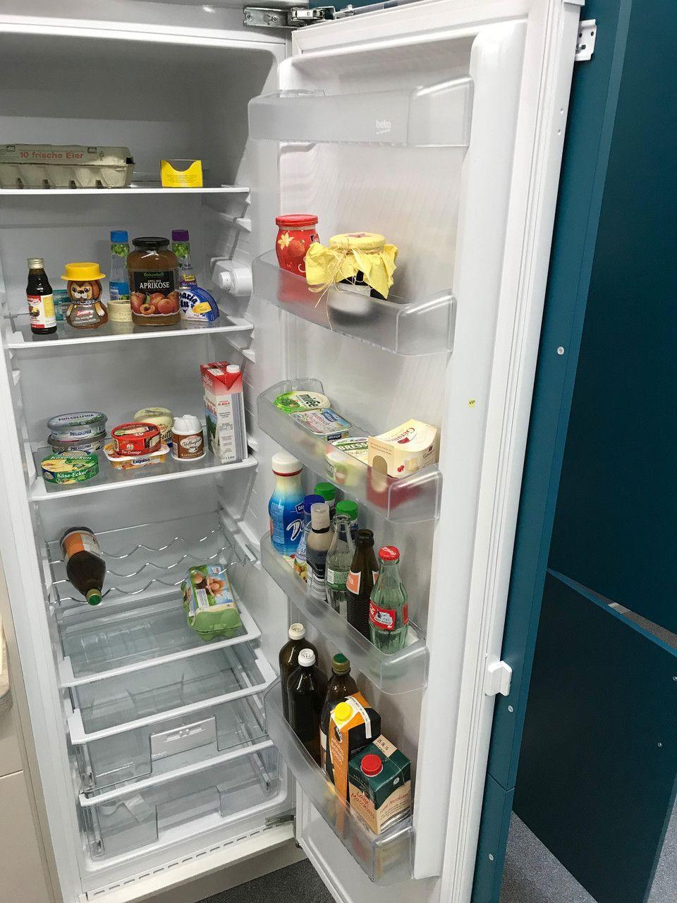 Unsere Ausstellung in Bischberg — Geöffneter weißer Einbau-Kühlschrank gefüllt mit Lebensmitteln