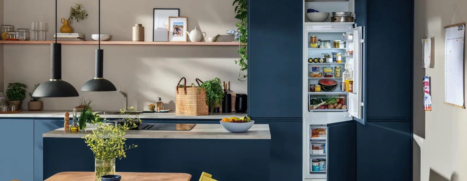 Constructa Einbaukühl-Gefrierkombination in moderner blauer Küche mit offenen Wandregalen